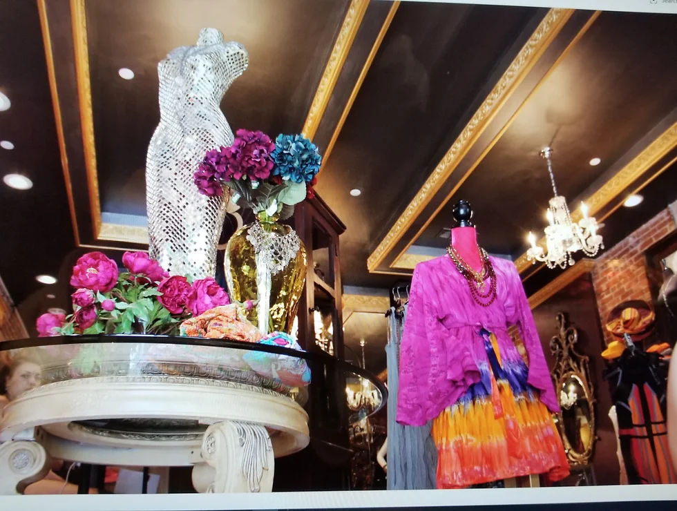 Boutique clothing display with floral decor.