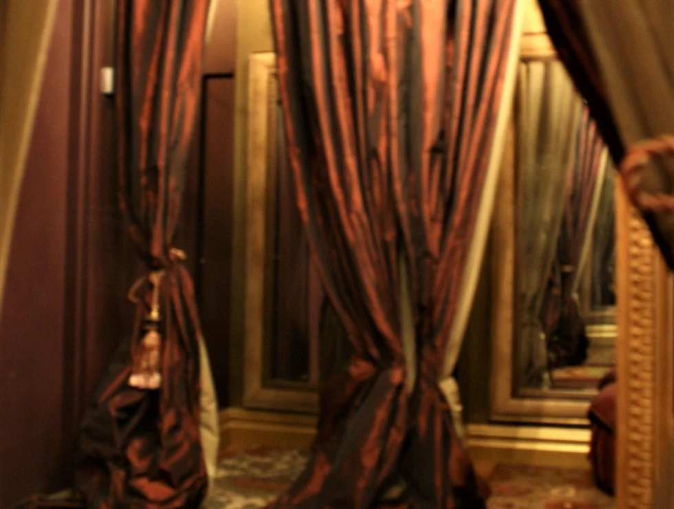 Here's an alt tag for the image: Dark red curtains in a dressing room.