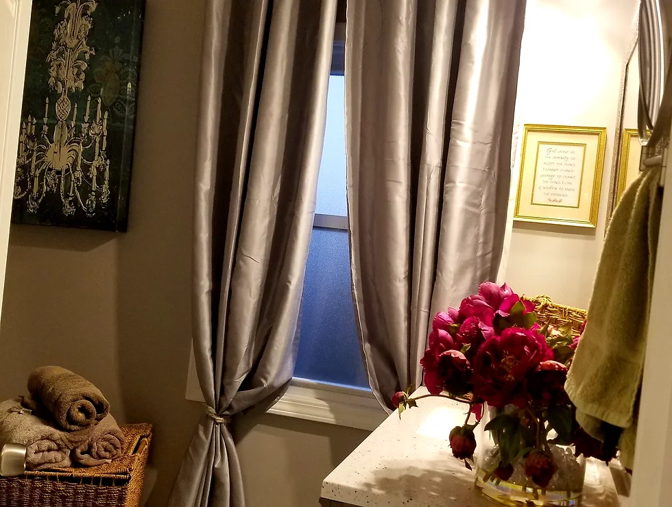 Bathroom with gray curtains and flowers.
