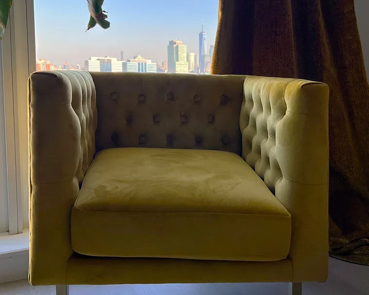 Mustard velvet armchair, city view.